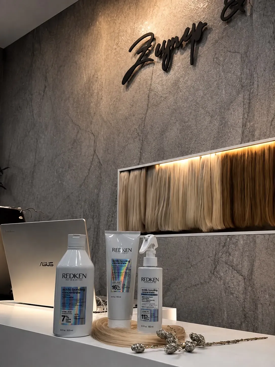 REDKEN Acidic Bonding Concentrate auf dem Tresen unter dem Salonschriftzug