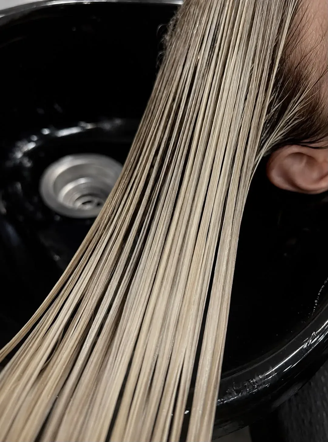 Frisch ausgewaschene blonde Längen am Waschbecken